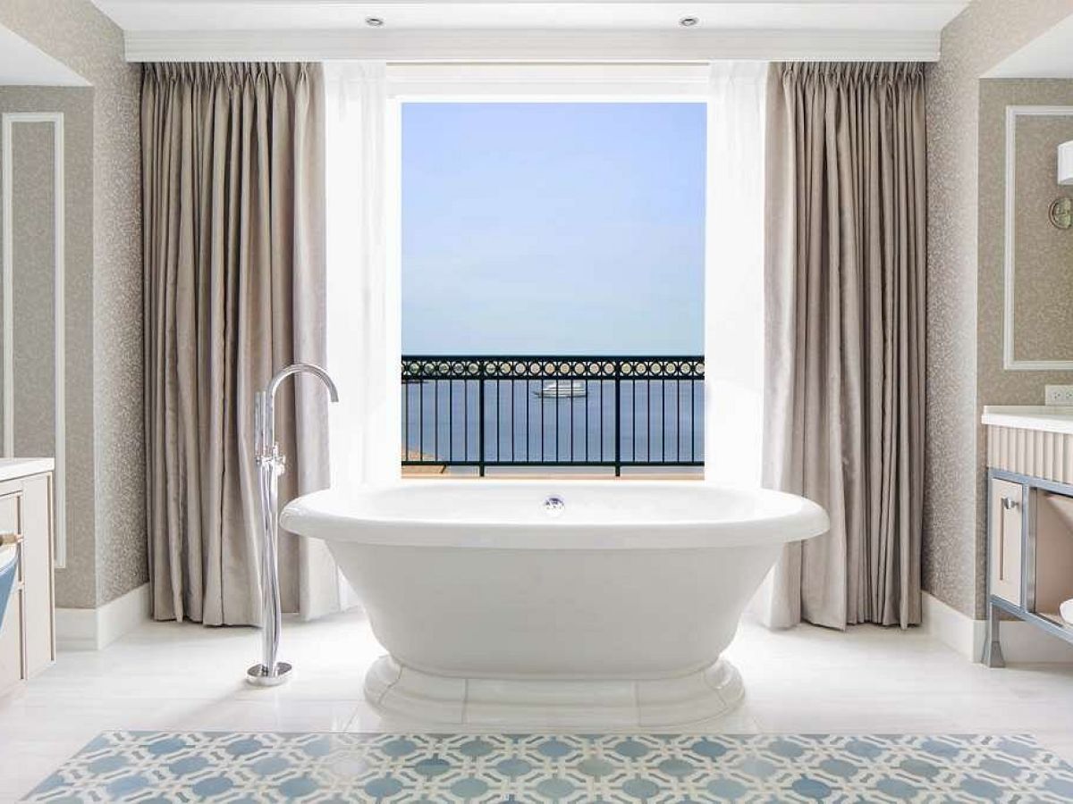 Elegant bathroom with a freestanding tub and harbor view.
