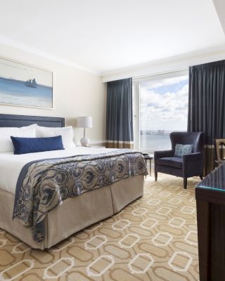 A well-appointed hotel room with a plush bed, elegant decor, and a view.