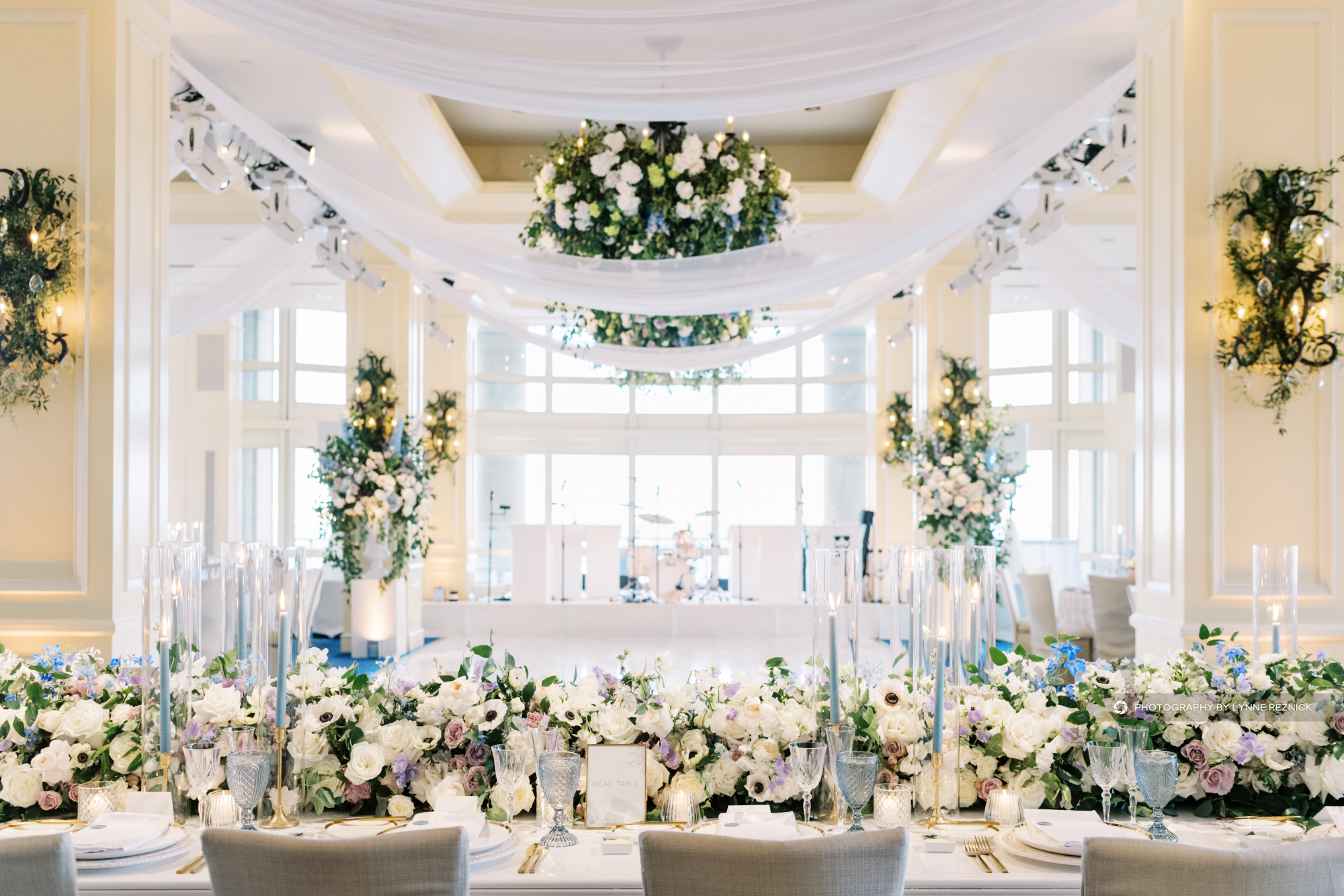 Elegant banquet hall set for an event with floral arrangements and soft lighting.
