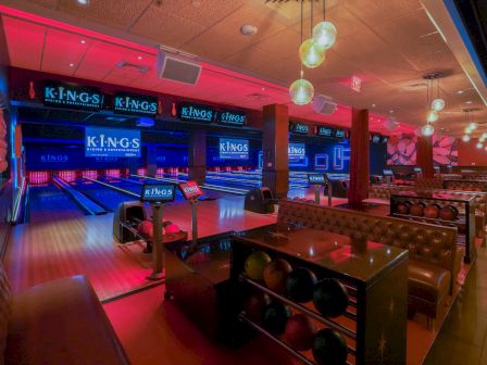 A bowling alley with lanes, seating, and colorful lighting.