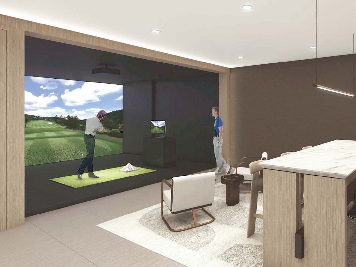 A person is playing golf on a simulator in a modern room.