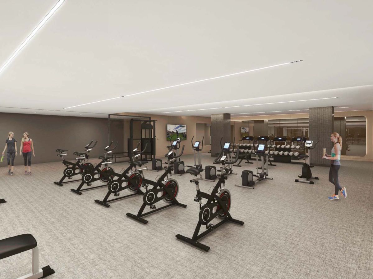Modern gym with cycling machines, weights, LED lights, and people exercising.