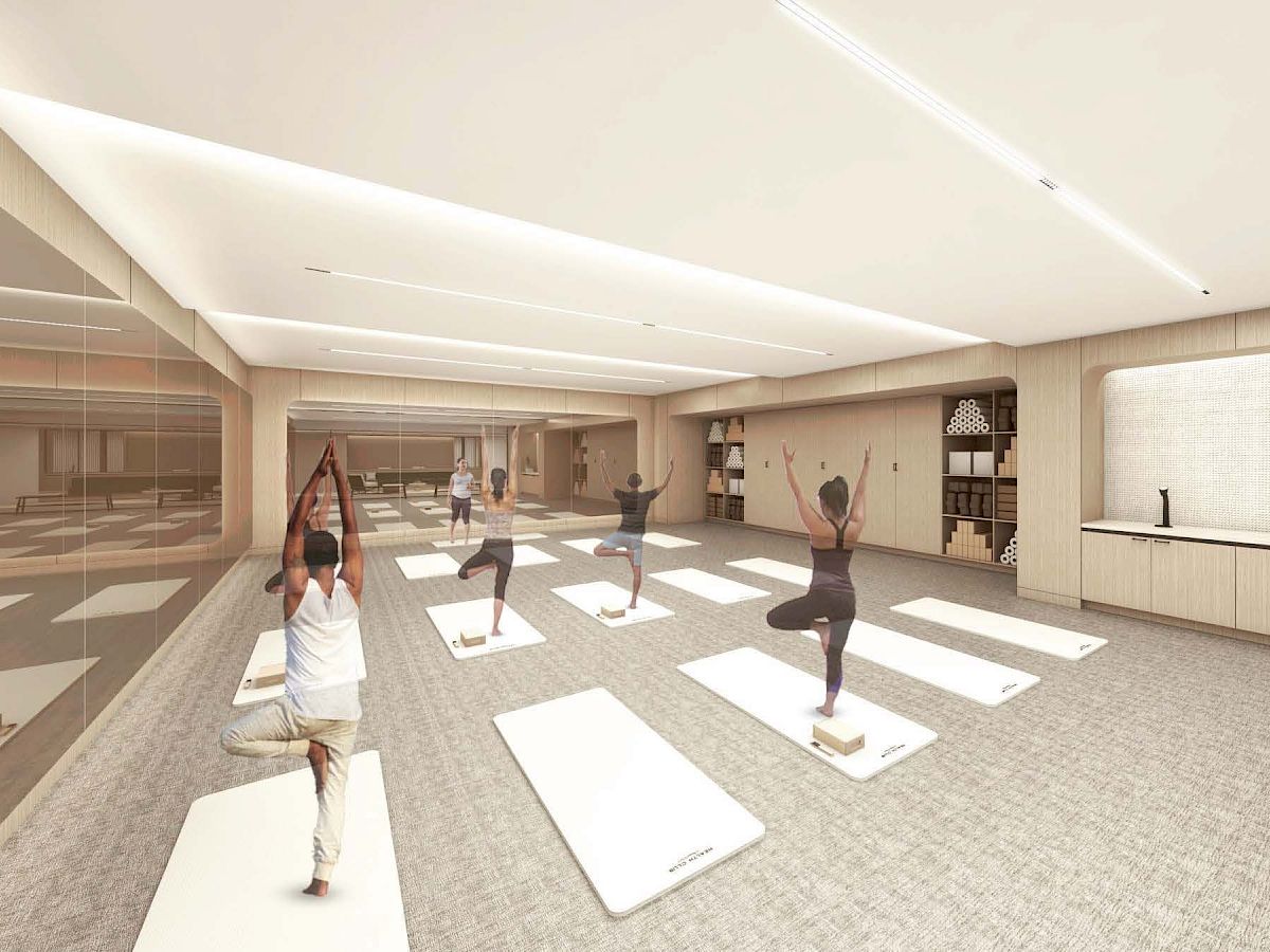 A yoga class in a modern, well-lit room with participants.
