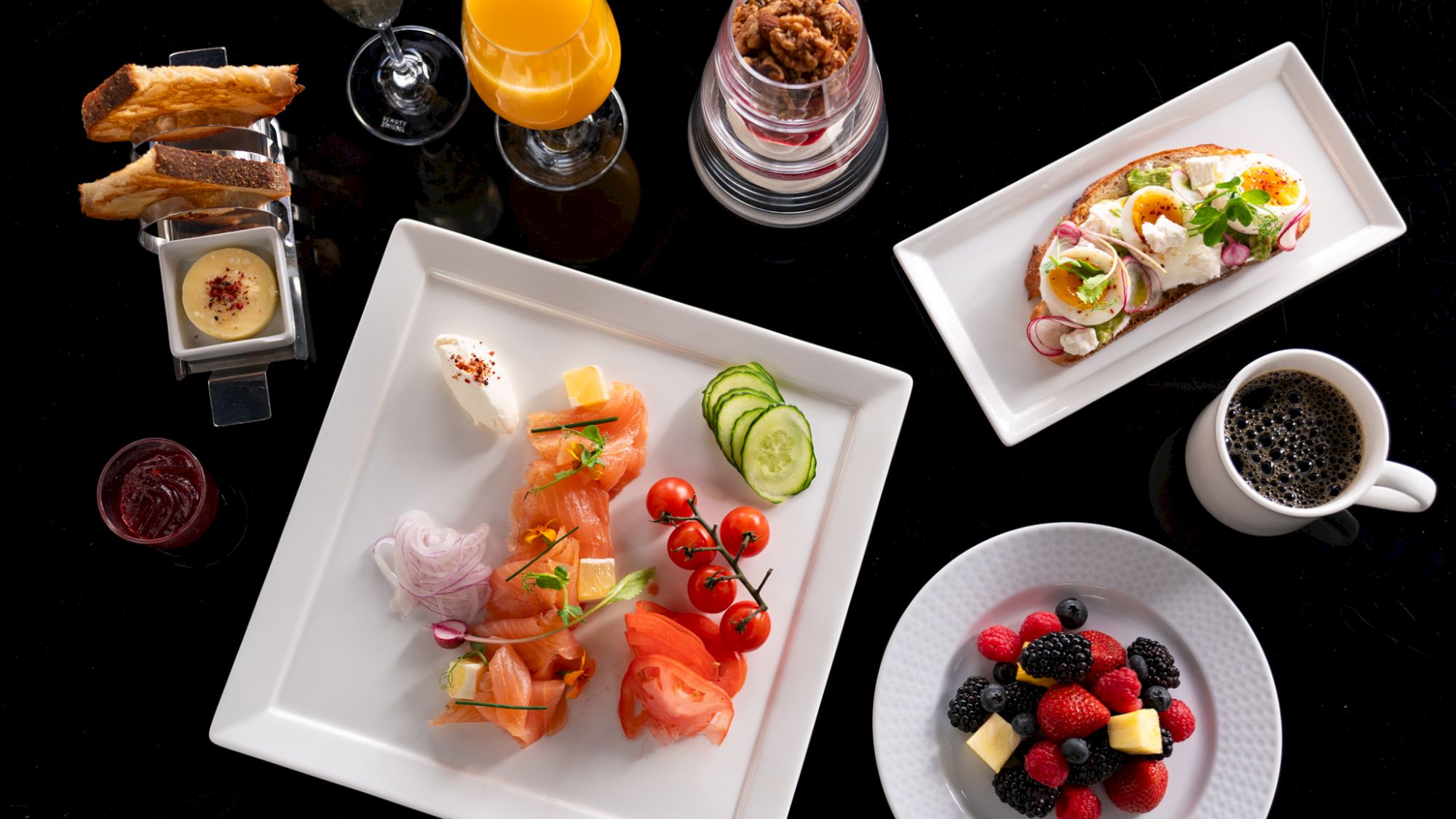 Elegant breakfast spread with smoked salmon, bagels, fruits, pastries.