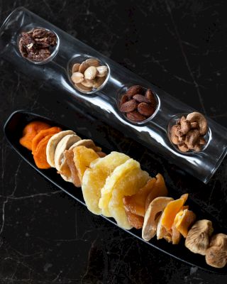 The image shows a variety of dried fruits and nuts organized neatly.