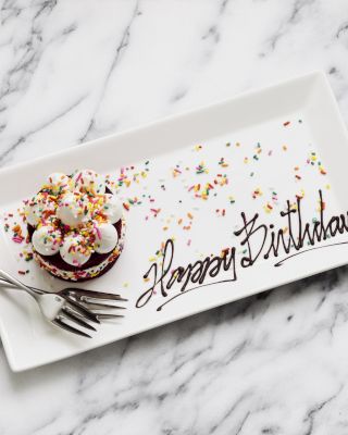 A birthday cupcake with sprinkles on a plate saying 
