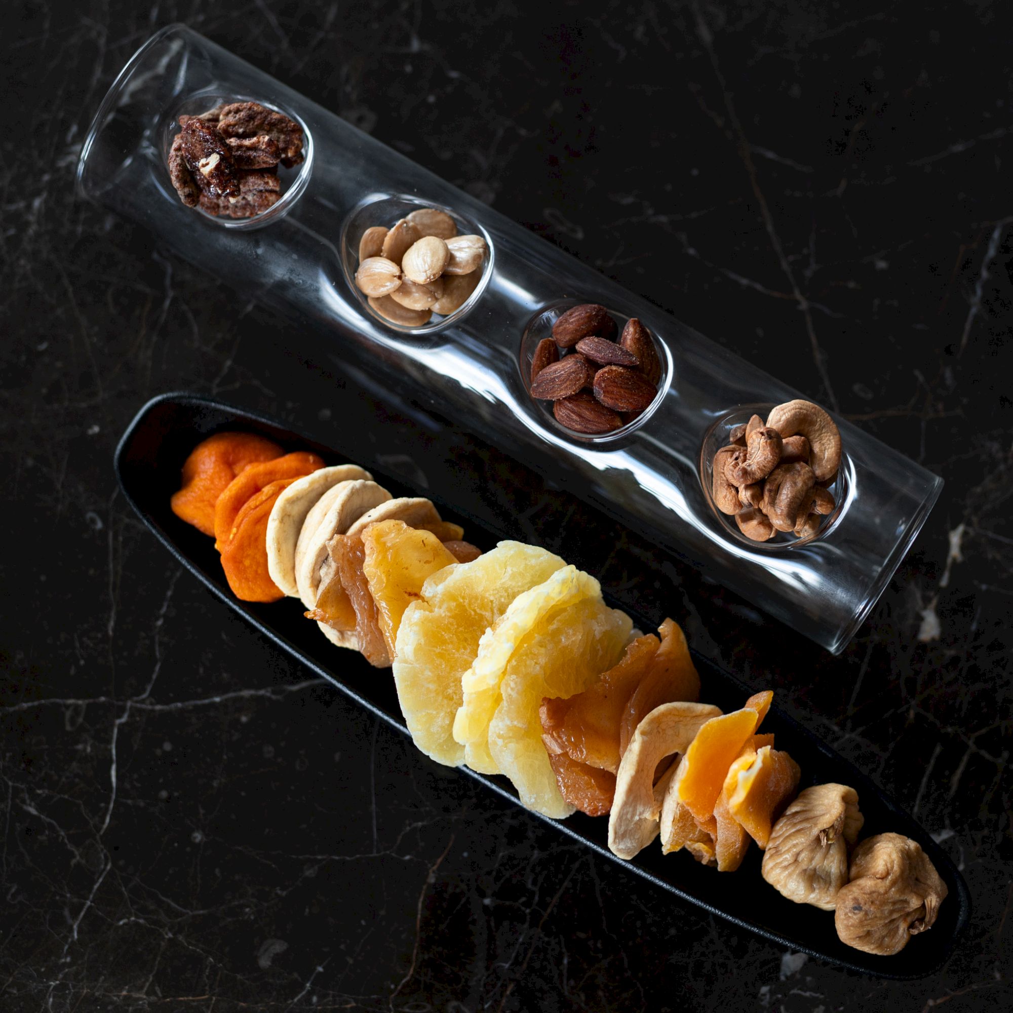 A platter with dried fruits and nuts is shown.