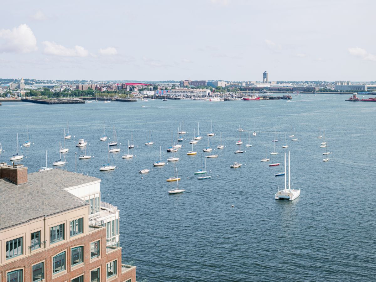 A harbor view with boats, buildings, and a dome structure near the water.