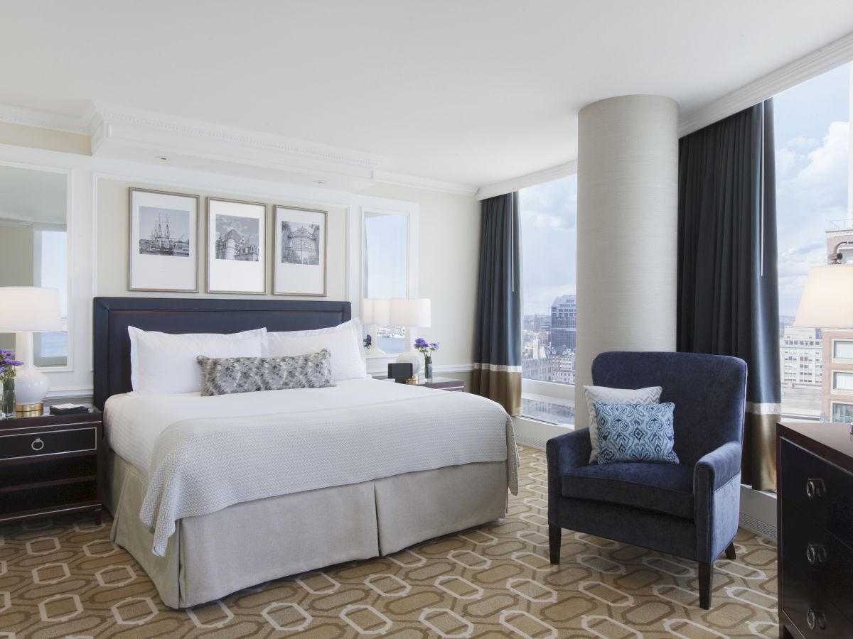 A well-appointed hotel room with a large bed, elegant furniture, and city views