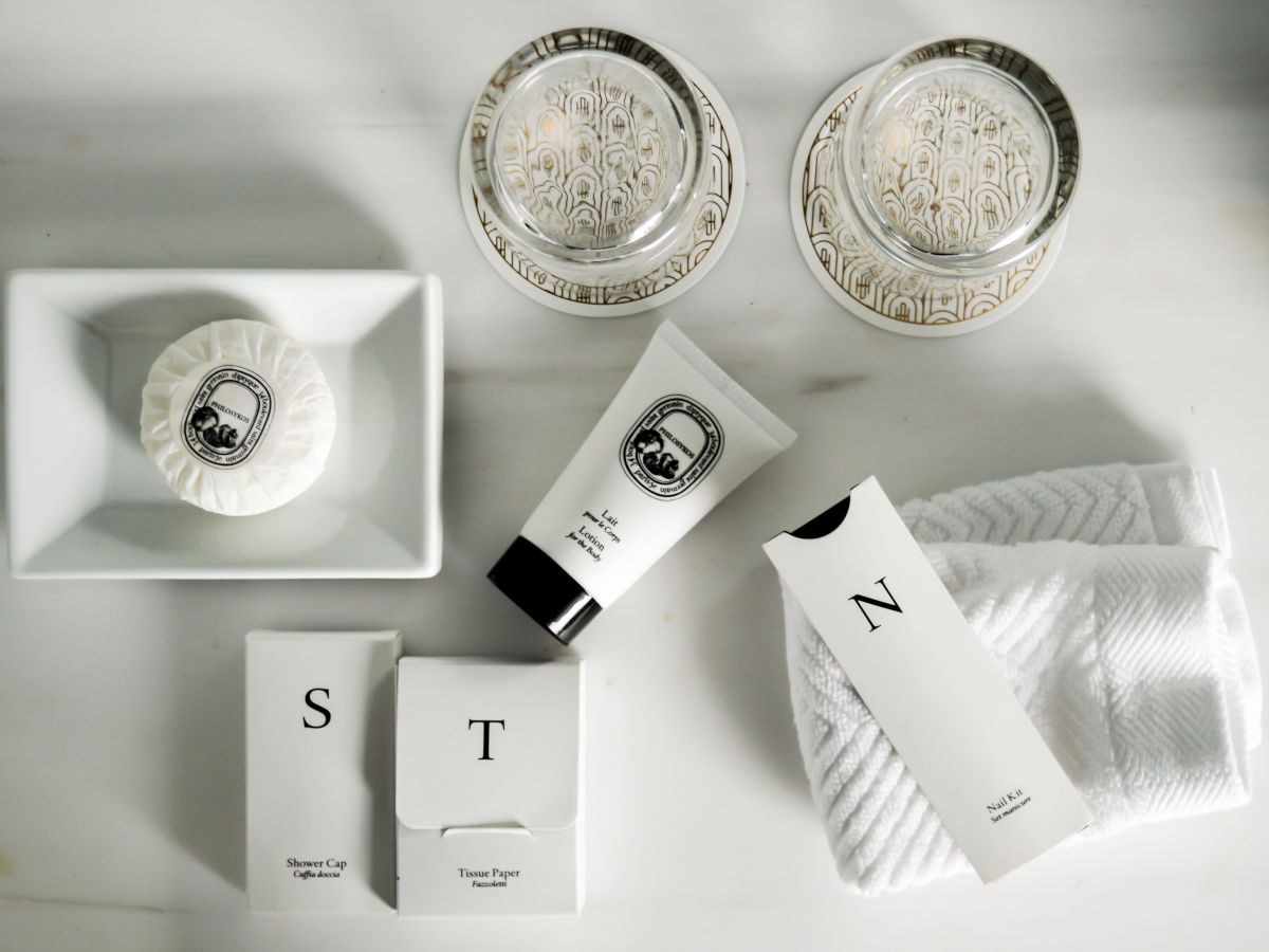 Elegant toiletry items on a white surface, including packaged soaps and creams.